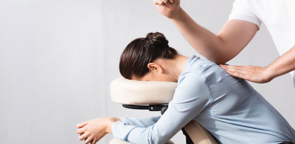 Une femme reçoit un massage professionnel sur chaise